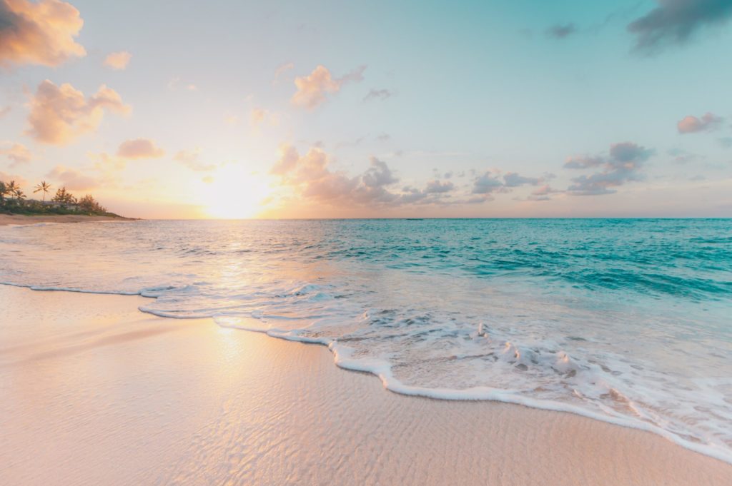 the sun shines over an ocean shore
