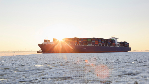 Container ship being escorted through ice to port