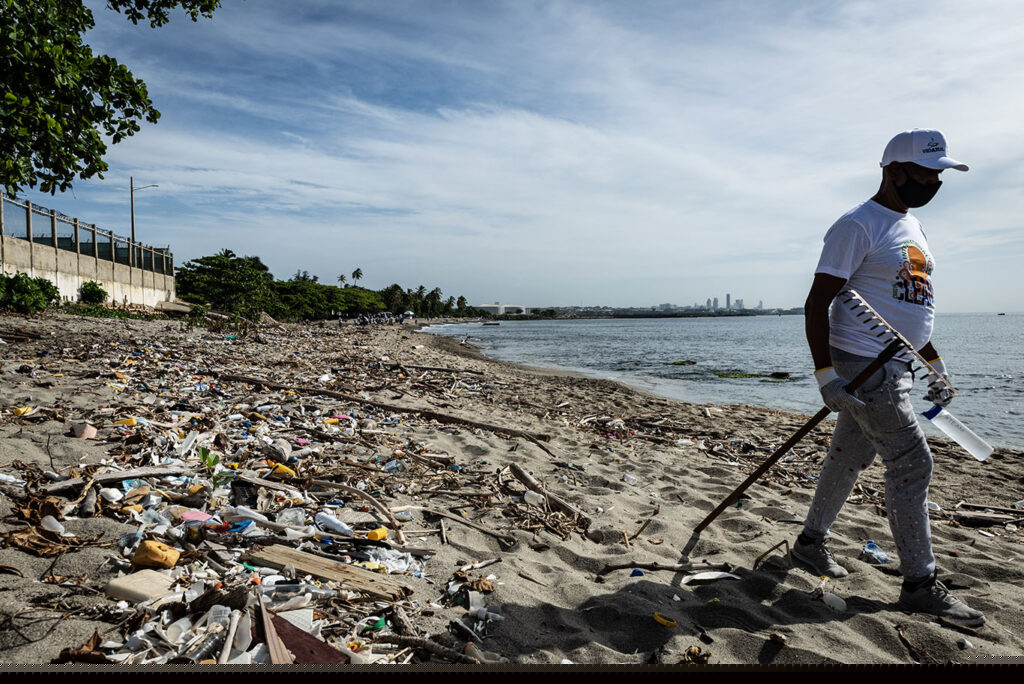 Man walking Playa Gringo beach during cleanup