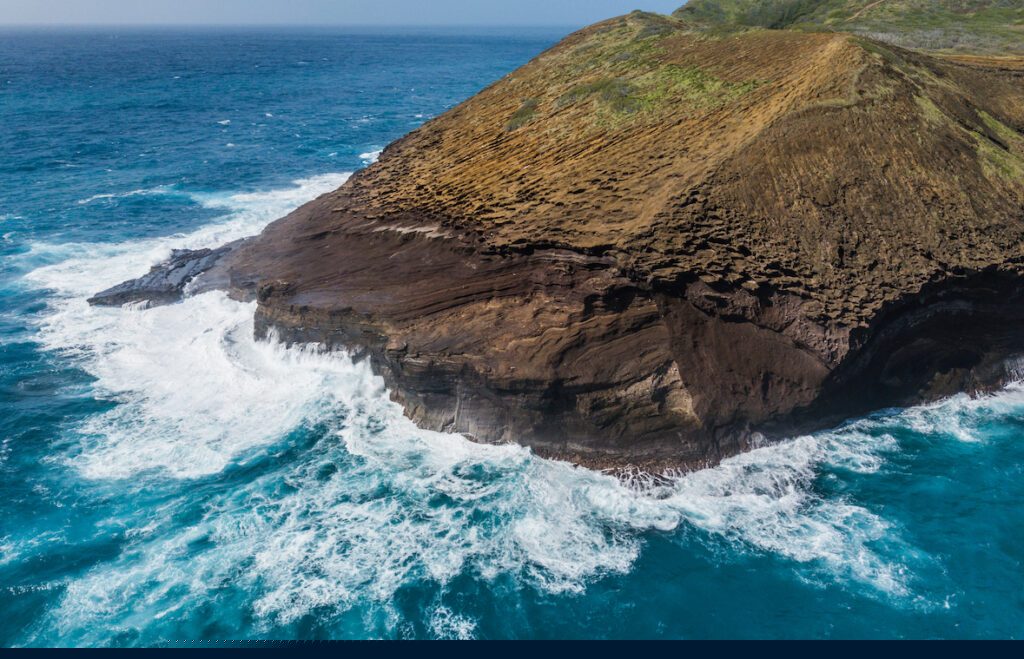 A wave crashes against a rocky shore UN Ocean Conference