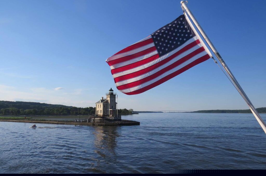 American flag near beach house and water